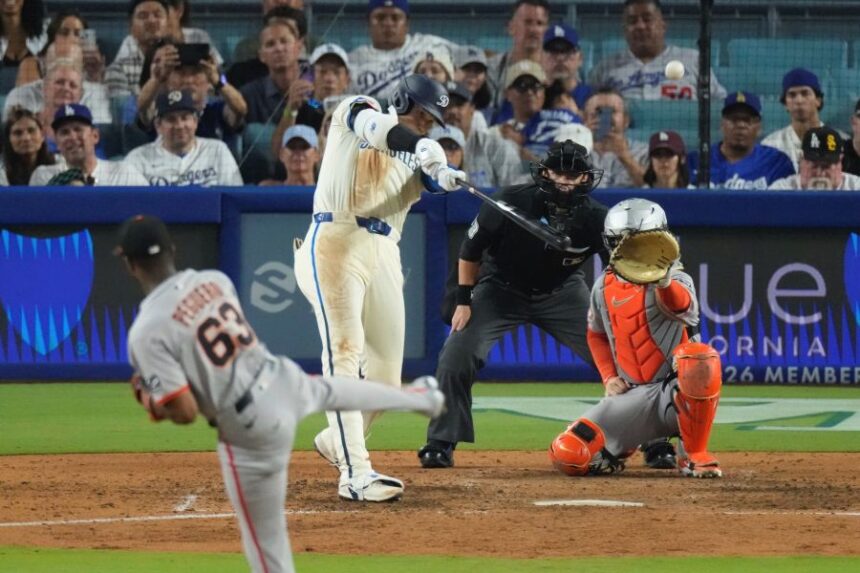 Los Angeles Dodgers' Shohei Ohtani, second from left, heads hits a solo home run as San Francisco Giants relief pitcher Joel Peguero, left, and catcher Patrick Bailey watch during the sixth inning of a baseball game, Saturday, Sept. 20, 2025, in Los Angeles. (AP Photo/Mark J. Terrill)