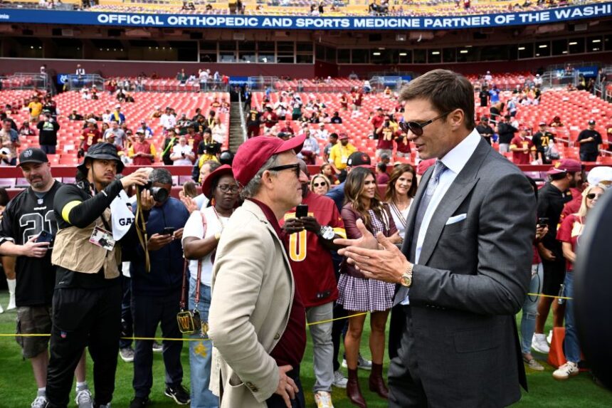 Washington Commanders owenr Josh Harris, right, talks with former NFL quarterback Tom Brady, right, before the start of an NFL football game against the New York Giants, Sunday, Sept. 7, 2025, in Landover, Md. (AP Photo/Nick Wass)
