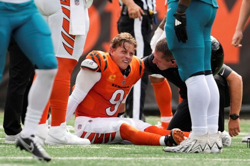 Cincinnati Bengals quarterback Joe Burrow (9) grimaces aft being sacked by Jacksonville Jaguars defensive tackle Arik Armstead (91) during the first half of an NFL football game, Sunday, Sept. 14, 2025, in Cincinnati. (AP Photo/Carolyn Kaster)