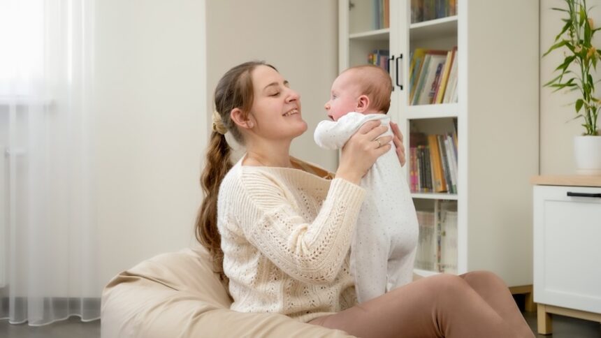 smiling young mother sitting in beanbag and holdin 2025 01 08 23 02 13 utc