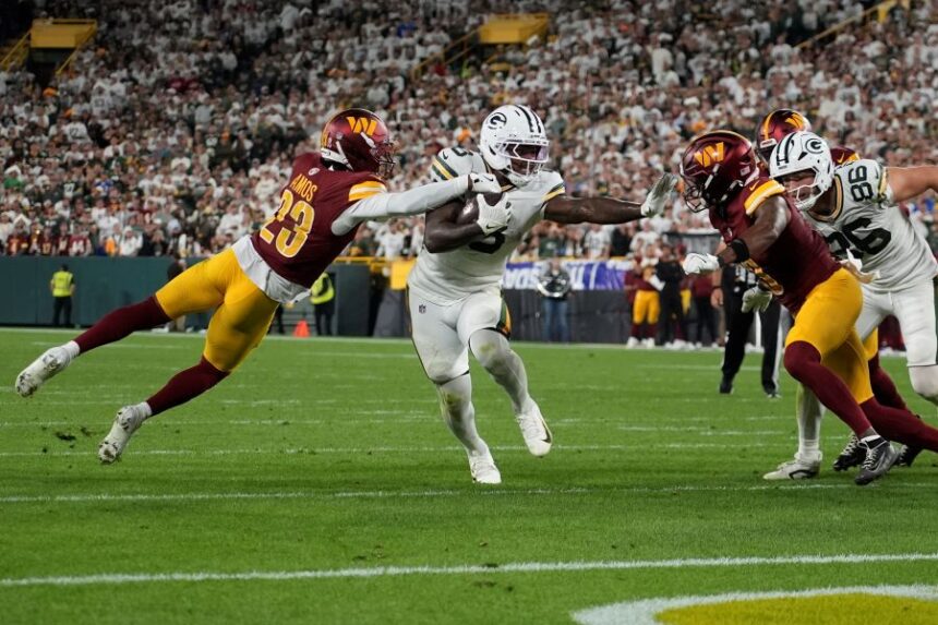 Green Bay Packers running back Josh Jacobs runs with the ball as Washington Commanders cornerback Trey Amos (23) defends during the second half of an NFL football game Thursday, Sept. 11, 2025, in Green Bay, Wis. (AP Photo/Morry Gash)