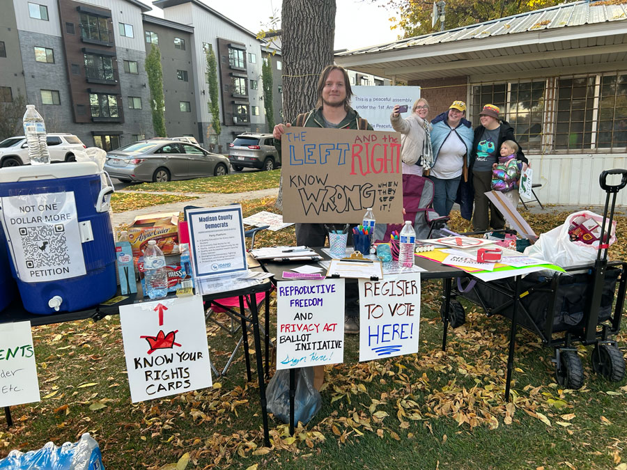 Morgan Craner of Rexburg takes a turn holding down the fort at the No Kings organizers' table, where protesters could add their name to a petition to get a reproductive freedom initiative on Idaho ballots in 2026. Emily Miller 