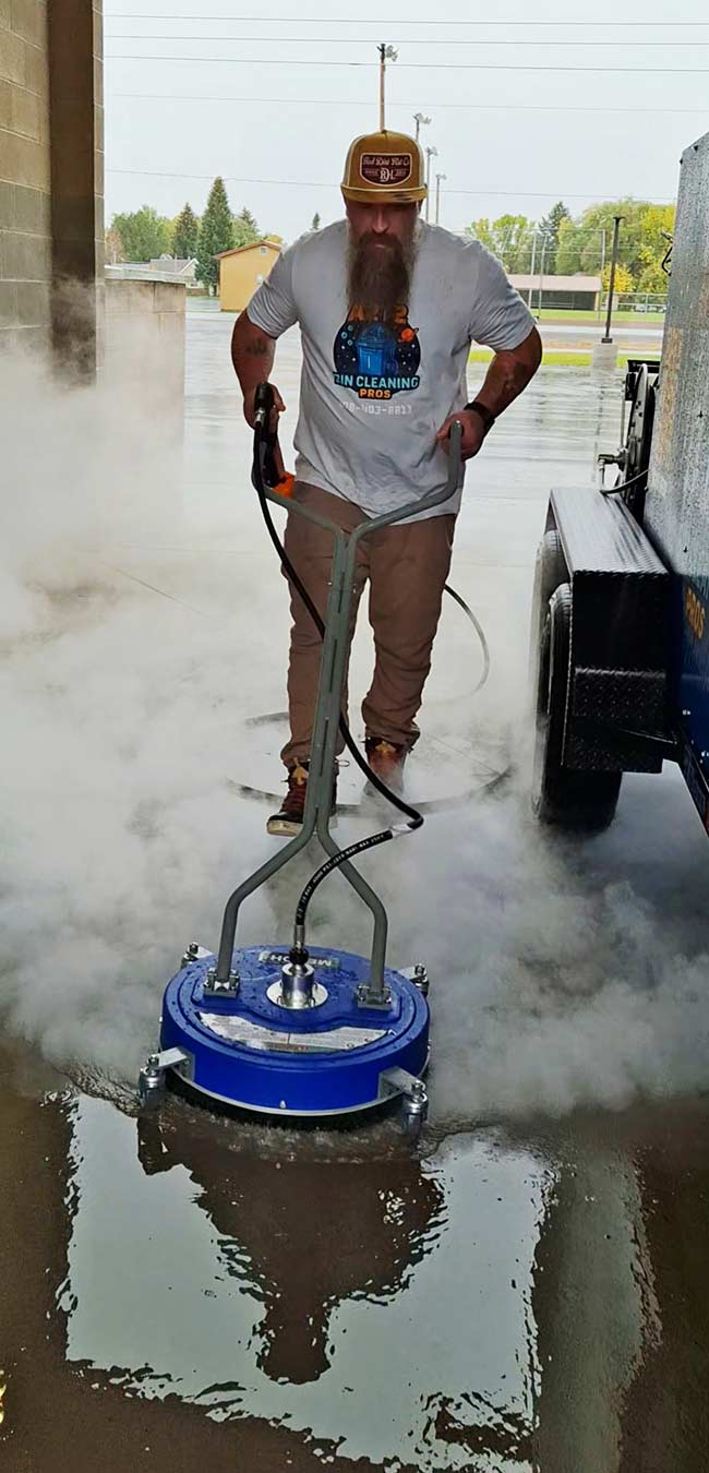 Austin pressure-washing the floor of his shop | Courtesy Jennifer Tanner