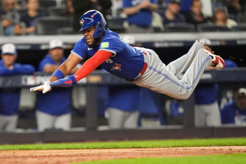Toronto Blue Jays Vladimir Guerrero Jr. dives into home plate to score against the New York Yankees during the third inning of Game 3 of baseball's American League Division Series, Tuesday, Oct. 7, 2025, in New York. (AP Photo/Frank Franklin II)