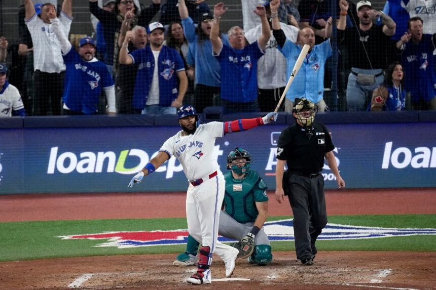 Toronto Blue Jays' Vladimir Guerrero Jr. watches his solo home run take flight against the Seattle Mariners during the fifth inning in Game 6 of baseball's American League Championship Series, Sunday, Oct. 19, 2025, in Toronto. (AP Photo/David J. Phillip)