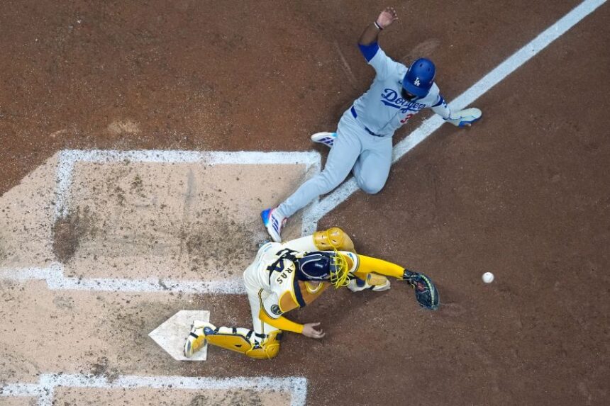 Los Angeles Dodgers' Teoscar Hernández is out at home as Milwaukee Brewers catcher William Contreras takes the throw during the fourth inning of Game 1 of baseball's National League Championship Series Monday, Oct. 13, 2025, in Milwaukee. (AP Photo/Morry Gash)