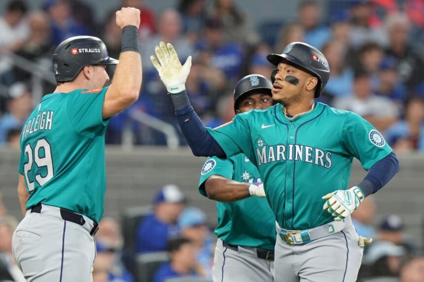 Seattle Mariners' Jorge Polanco, right, celebrates after his a three-run home run with Cal Raleigh (29) during the fifth inning of Game 2 of baseball's American League Division Series against the Toronto Blue Jays in Toronto, Monday, Oct. 13, 2025. (Frank Gunn/The Canadian Press via AP)