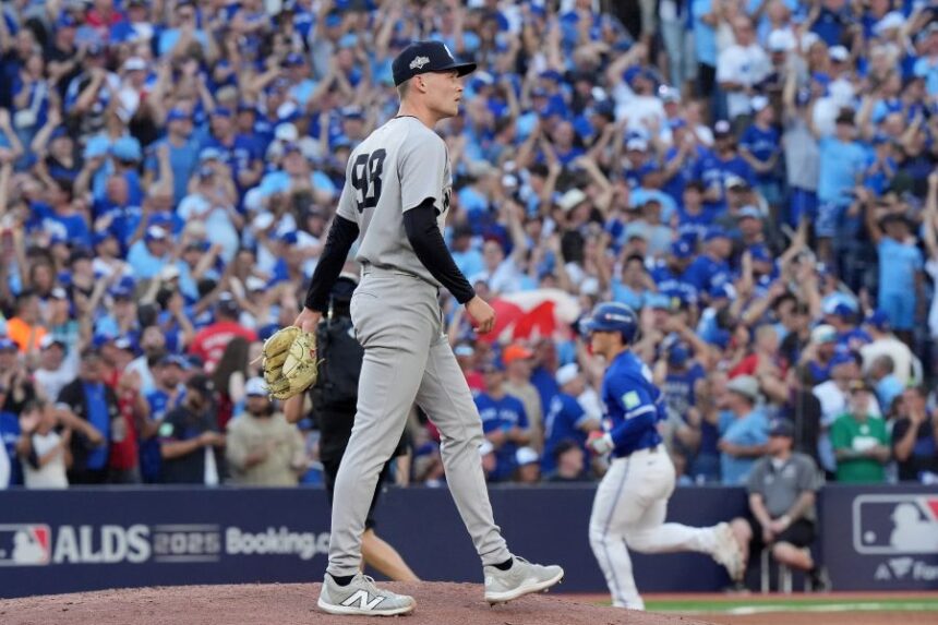 New York Yankees pitcher Will Warren, foreground, reacts as Toronto Blue Jays' Daulton Varsho, back right, rounds the bases after hitting a two-run home run during the fourth inning of Game 2 of baseball's American League Division Series in Toronto, Sunday, Oct. 5, 2025. (Frank Gunn/The Canadian Press via AP)