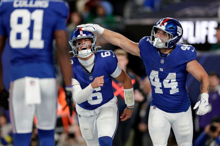 New York Giants' Jaxson Dart, center, and Cam Skattebo celebrate after a touchdown during the first half of an NFL football game against the Philadelphia Eagles Thursday, Oct. 9, 2025, in East Rutherford, N.J. (AP Photo/Adam Hunger)
