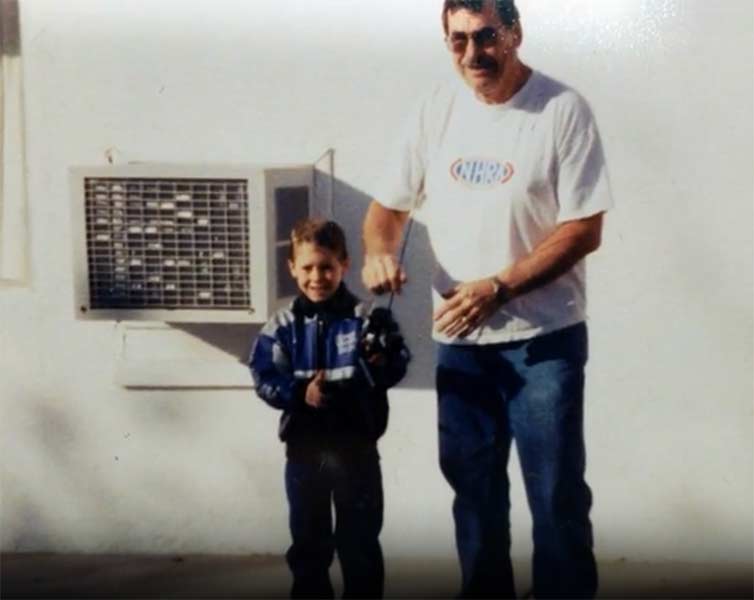 Stommel holding a fishing pole with his young son. | Courtesy photo