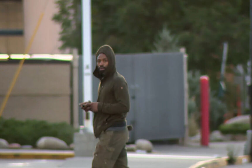 suspect walks past TV crew