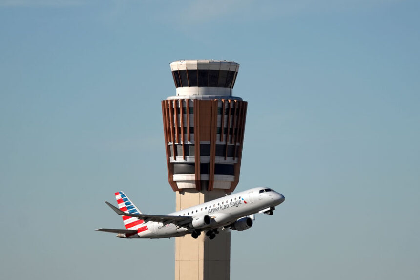 An American Airlines American Eagle jet flies past the air traffic control tower at Phoenix Sky Harbor International Airport Saturday, Nov. 8, 2025, in Phoenix. (AP Photo/Ross D. Franklin)