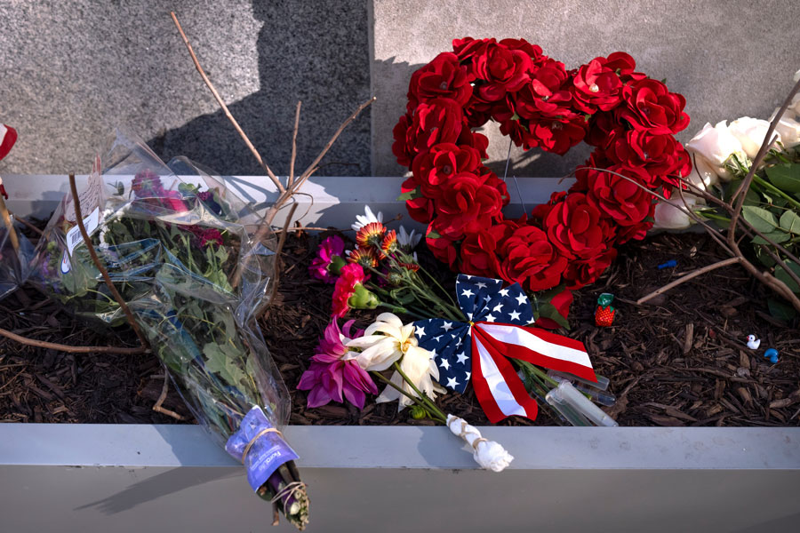 A small memorial of flags, flowers, other items are seen in a planter, Friday, Nov. 28, 2025, near the site where two National Guard members were shot in Washington. | Mark Schiefelbein, Associated Press