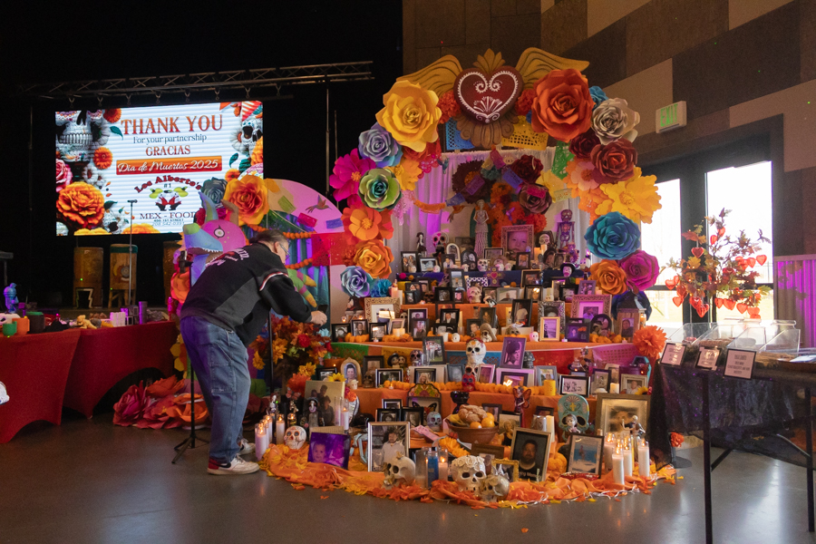 A man showing family members on his phone a photo of a passed loved one an an alter at Sunday's event. | Daniel V. Ramirez, EastIdahoNews.com