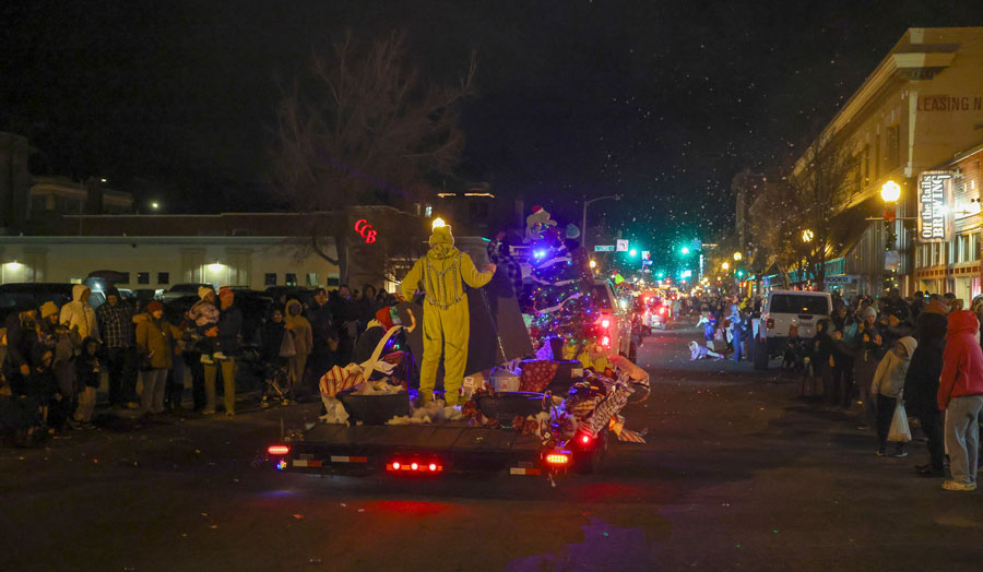 Children look out the window of a homemade gingerbread house float as it makes its way through the  2025 Christmas Night Lights Parade.   