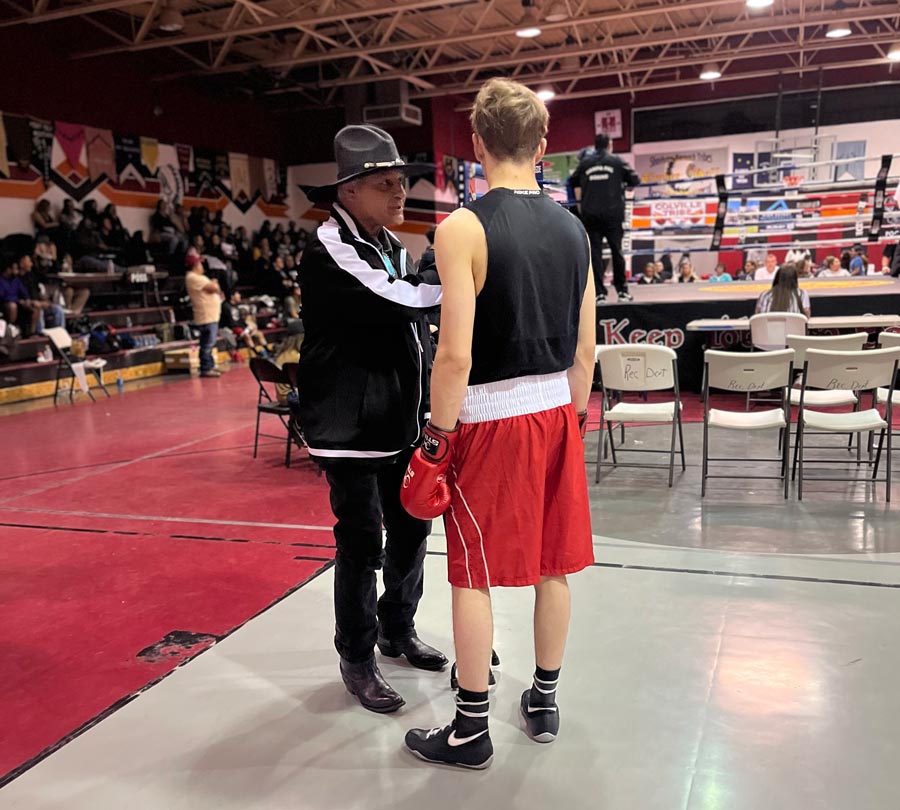 Former U.S. Navy and U.S. Army boxing coach Nars Martinez discusses strategy with Idaho Falls Boxing Club member Owen Taule prior to a match in Fort Hall this summer. | Courtesy Corey Taule