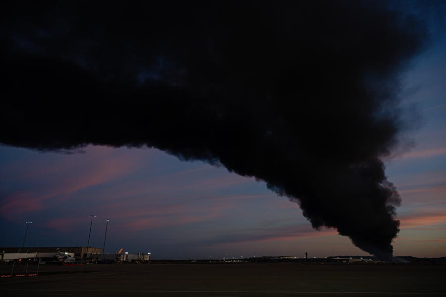 A plume of smoke wafts over airport property after reports of a plane crash at Louisville International Airport, Tuesday, Nov. 4, 2025, in Louisville, Ky. (AP Photo/Jon Cherry)