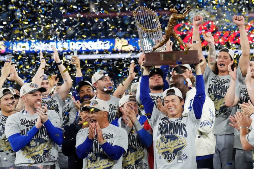 Los Angeles Dodgers pitcher Yoshinobu Yamamoto, center right, lifts the World Series MVP trophy as the Dodgers celebrate after defeating the Toronto Blue Jays in Game 7 of baseball's World Series, Sunday, Nov. 2, 2025, in Toronto. (Nathan Denette/The Canadian Press via AP)