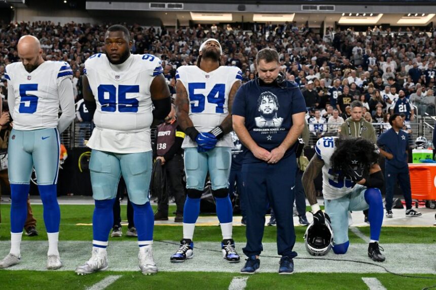 Dallas Cowboys players Bryan Anger (5), Kenny Clark (95), Sam Williams (54), Marist Liufau (35) and Cowboys linebackers coach Dave Borgonzi pause during a moment of silence for teammate Marshawn Kneeland prior to an NFL football game against the Las Vegas Raiders Monday, Nov. 17, 2025, in Las Vegas, in memory of Kneeland who passed away earlier this month. (AP Photo/David Becker)