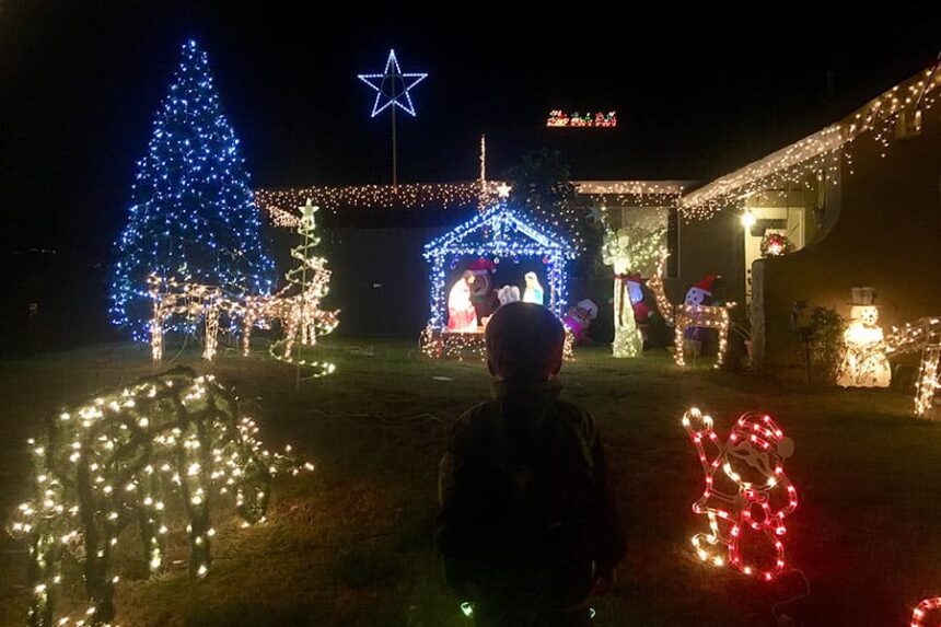 toddler looking at house Christmas lights