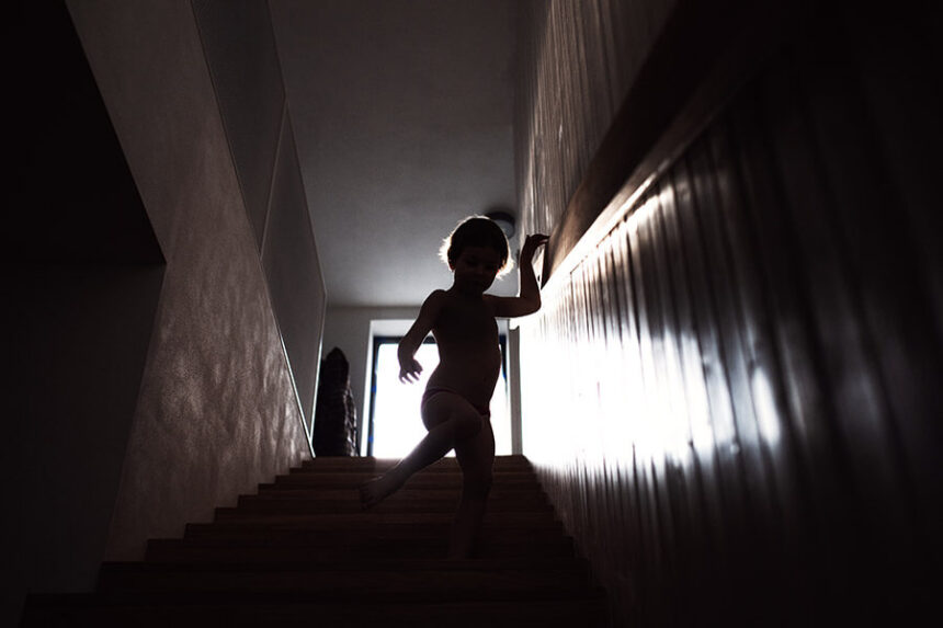 small child walks down stairs