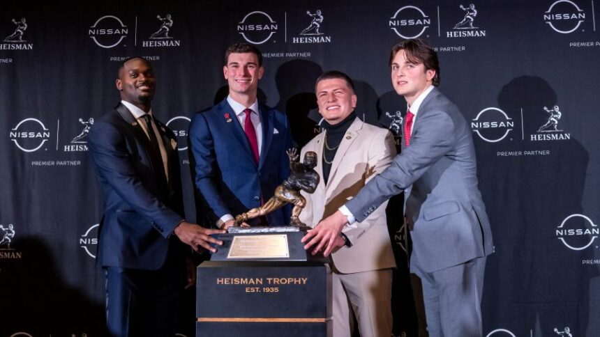 Heisman Trophy finalists, from left to right, Notre Dame running back Jeremiah Love, Indiana quarterback Fernando Mendoza, Vanderbilt quarterback Diego Pavia and Ohio State quarterback Julian Sayin pose with the trophy after attending an NCAA college football news conference before the award ceremony, Saturday, Dec. 13, 2025, in New York. (AP Photo/Eduardo Munoz Alvarez)