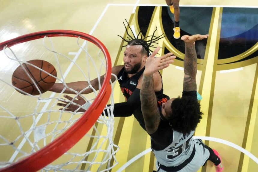 New York Knicks guard Jalen Brunson, left, shoots the ball past San Antonio Spurs forward Julian Champagnie (30) during an NBA Cup championship basketball game, Tuesday, Dec. 16, 2025, in Las Vegas. (Kirby Lee/Pool Photo via AP)