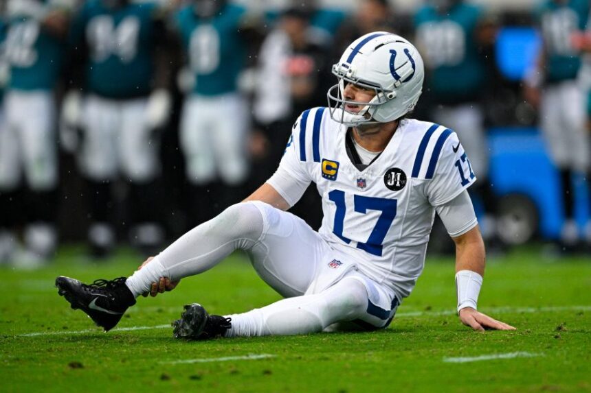 Indianapolis Colts quarterback Daniel Jones (17) grabs his leg after an injury during the first half of an NFL football game against the Jacksonville Jaguars, Sunday, Dec. 7, 2025, in Jacksonville, Fla. (AP Photo/Phelan M. Ebenhack)