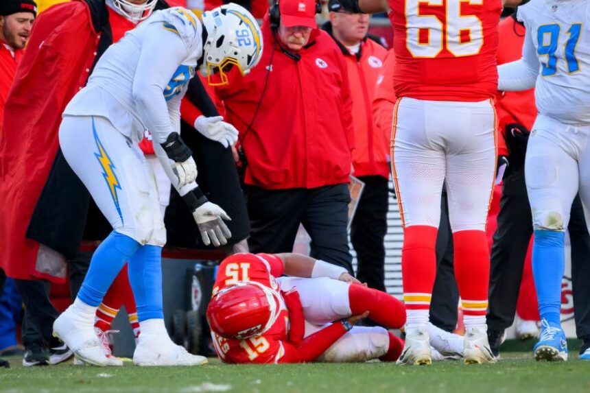 Los Angeles Chargers defensive tackle Justin Eboigbe (92) checks on Kansas City Chiefs quarterback Patrick Mahomes (15) as Chiefs head coach Andy Reid, center, looks on after Mahomes was injured during the second half of an NFL football game, Sunday, Dec. 14, 2025 in Kansas City, Mo. (AP Photo/Reed Hoffmann)