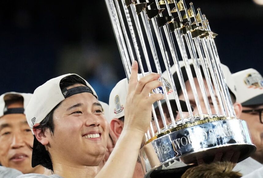 FILE - Los Angeles Dodgers pitcher Shohei Ohtani lifts the trophy as the Dodgers celebrate after defeating the Toronto Blue Jays in Game 7 of baseball's World Series, Sunday, Nov. 2, 2025, in Toronto. (Nathan Denette/The Canadian Press via AP, File)