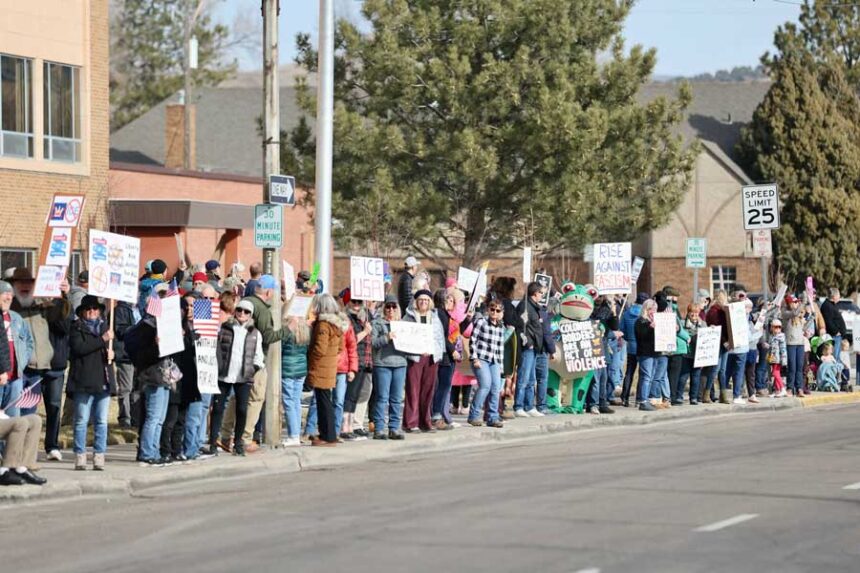 Protesters in Pocatello stand along East Center Street holding signs with messages that oppose U.S. Immigration and Customs Enforcement, ICE