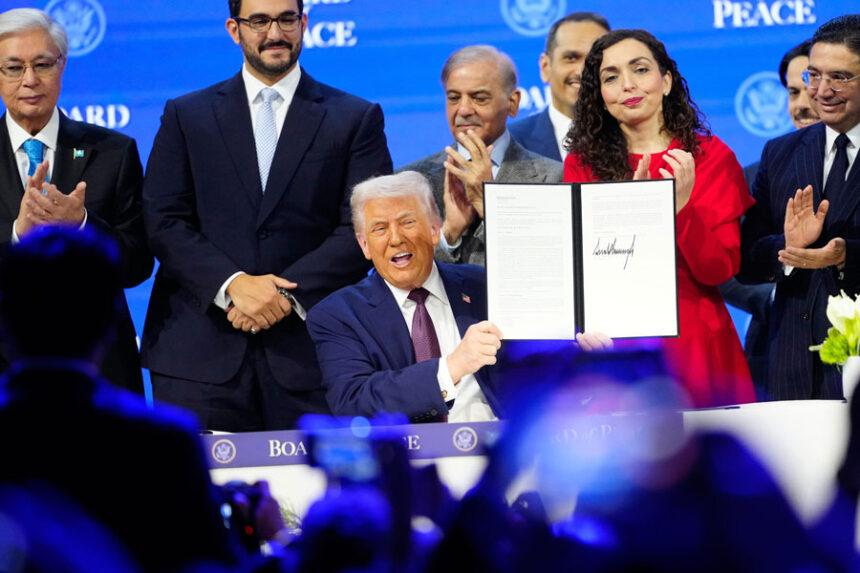 President Donald Trump holds the charter during a signing ceremony on his Board of Peace initiative at the Annual Meeting of the World Economic Forum in Davos, Switzerland, Thursday, Jan. 22, 2026. (AP Photo/Markus Schreiber)