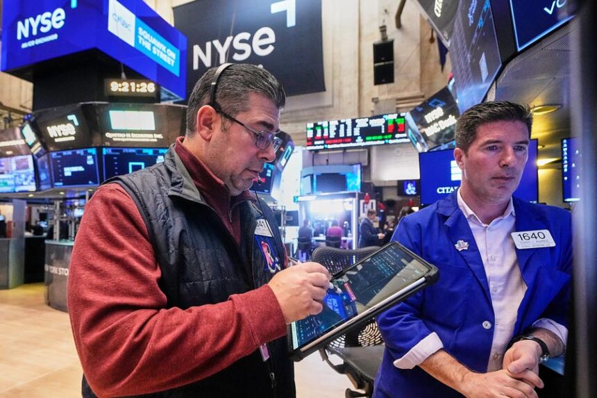 Trader Michael Capolino, left, and Specialist Thomas McArdle work on the floor of the New York Stock Exchange, Monday, Jan. 26, 2026. (AP Photo/Richard Drew)