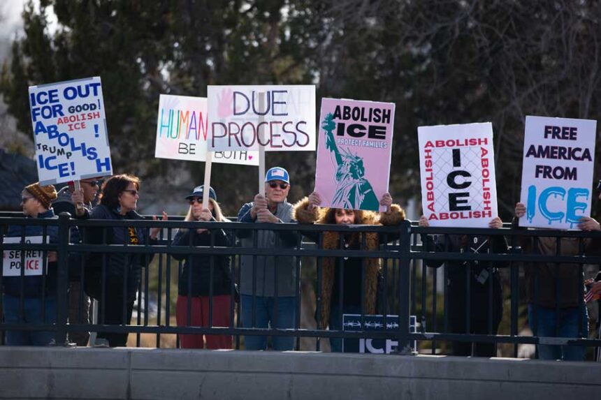 Protestors hold signs with messages against U.S. Immigration and Customs Enforcement on Broadway Bridge in Idaho Falls on Saturday, Jan. 31, 2026.