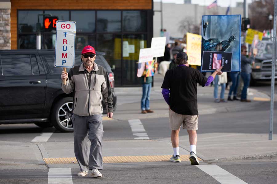 Michael Armstrong, a counterprotester, walks across the street holding a sign during a rally against U.S. Immigration and Customs Enforcement in Idaho Falls on Saturday, Jan. 31, 2026.