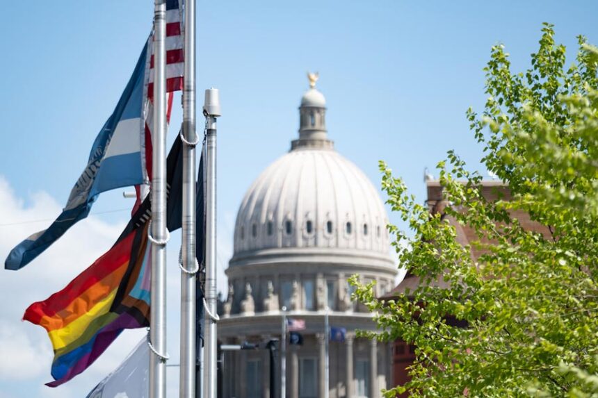 A pride flag flies in front of Boise City Hall, just blocks from the Idaho Capitol. The flag flies below the city’s own banner and in April shared the flagpole with a flag honoring organ donation. The city also displays the U.S. flag, a POW/MIA flag and a state of Idaho flag. | Erika Bolstad, Stateline