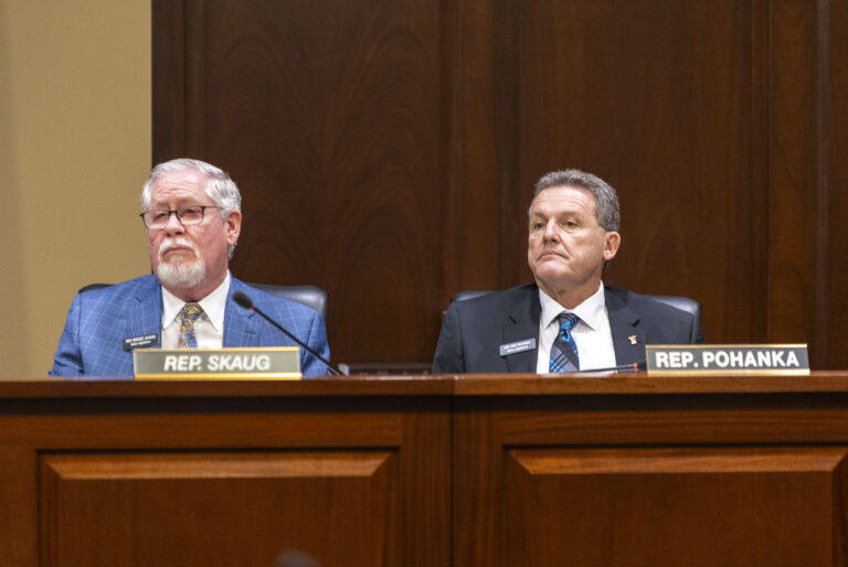 Idaho state Reps. Bruce Skaug, R-Nampa, and Mike Pohanka, R-Jerome, listen to proceedings during the House State Affairs Committee on Jan. 7, 2025, at the State Capitol Building in Boise. (Pat Sutphin for the Idaho Capital Sun