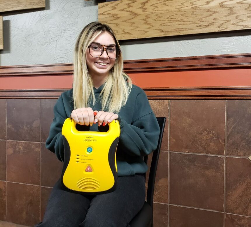 Rigby softball player and her Automated External Defibrillator. | Allan Steele, EastIdahoSports.com.