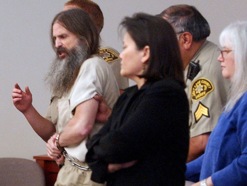 Brian David Mitchell, left, is escorted out of 3rd District Court of Judge Judith Atherton during his competency hearing after shouting a Biblical admonition on July 7, 2005, in Salt Lake City, Utah.