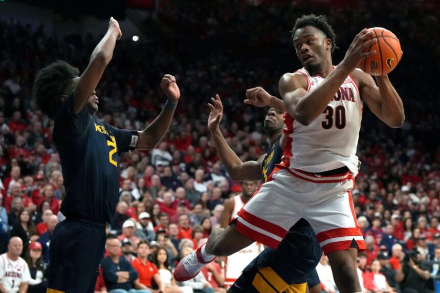 Arizona forward Tobe Awaka drives on West Virginia guard Amir Jenkins (2) and guard Honor Huff during the second half of an NCAA college basketball game, Saturday, Jan. 24, 2026, in Tucson, Ariz. (AP Photo/Rick Scuteri)