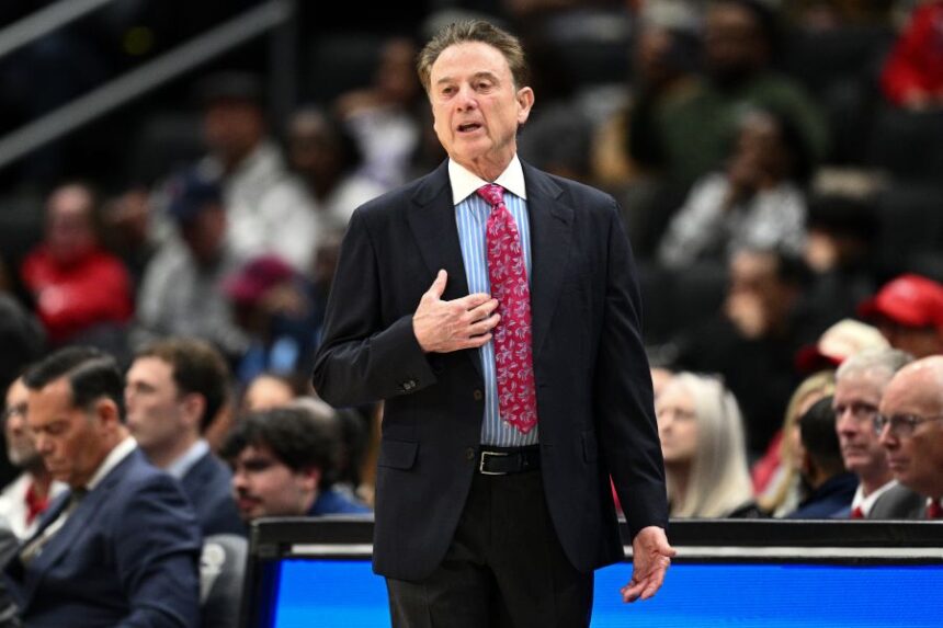 St. John's head coach Rick Pitino, left, is presented with a jersey by Ed Kull for his 900th win before an NCAA college basketball game against Butler, Wednesday, Jan. 28, 2026, in New York. (AP Photo/Heather Khalifa)