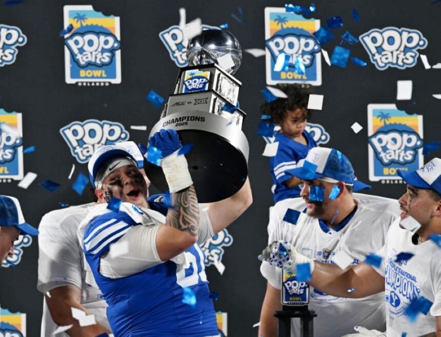 BYU offensive lineman Weylin Lapuaho lifts the trophy after the Cougars defeated Georgia Tech in the Pop-Tarts Bowl. | Scott G. Winterton, Deseret News.