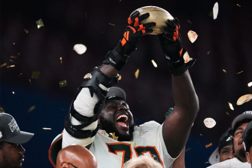 Miami offensive lineman Markel Bell holds up a trophy after winning the Fiesta Bowl NCAA college football playoff semifinal game against Mississippi, Thursday, Jan. 8, 2026, in Glendale, Ariz. (AP Photo/Ross D. Franklin)