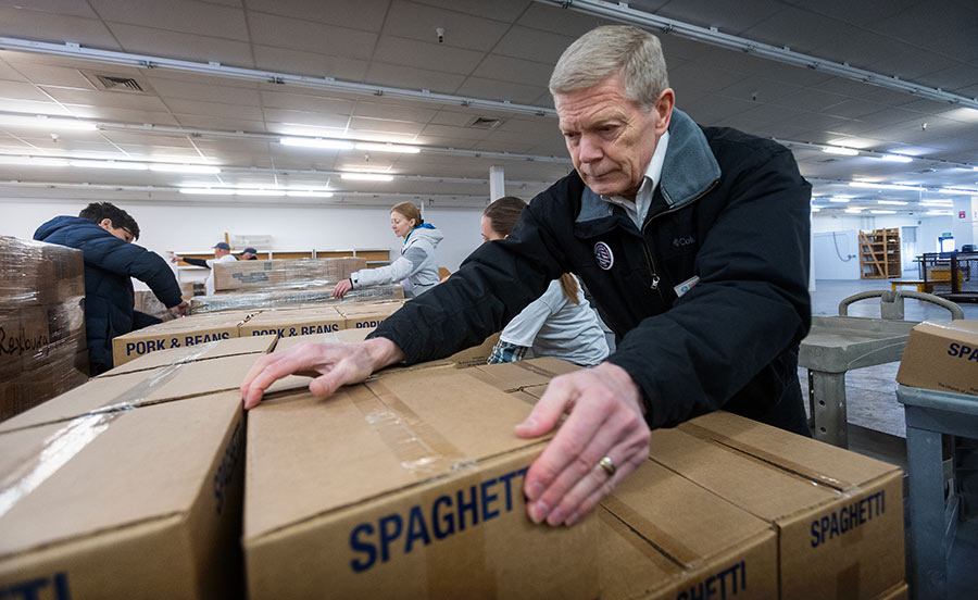volunteers help unload food truck donation