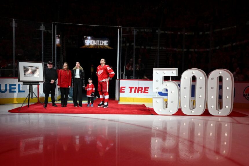 Detroit Red Wings right wing Patrick Kane (88) stands with his family, from left to right, father Patrick Sr., mother Donna, girlfriend Amanda Grahovec, and son Patrick III while being honored by the team for scoring his 500th career goal earlier in the month before an NHL hockey game against the Ottawa Senators, Sunday, Jan. 18, 2026, in Detroit. (AP Photo/Lon Horwedel)