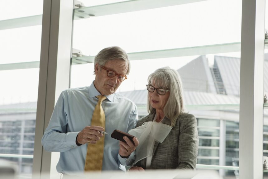 two seniors engaged with a smartphone in a modern 2026 01 09 09 16 35 utc
