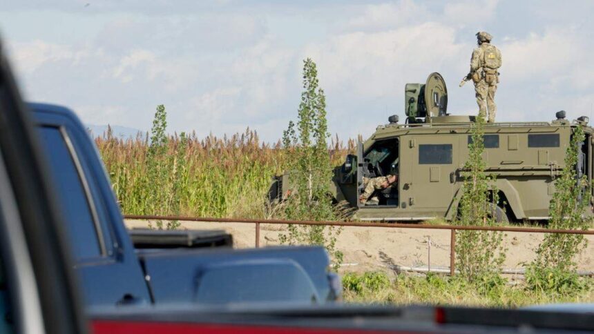 A member of the FBI’s SWAT team stands on top of an armored vehicle during a raid at La Catedral Arena in Wilder that resulted in the arrest of five people on criminal charges and dozens of others on immigration violations. | FBI