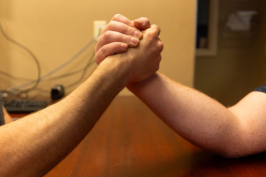 EastIdahoNews.com reporter Rett Nelson (left) and EastIdahoNews.com accountant, Kolby Mumm, face off in an arm wrestling tournament in the newsroom. | Daniel V. Ramirez, EastIdahoNews.com