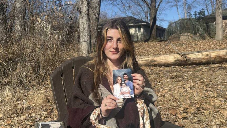 Mackenzie Burt, 19, holds a photo of her parents and herself as a child, taken before her father, Jeramy Burt, disappeared in Feb. 2007.