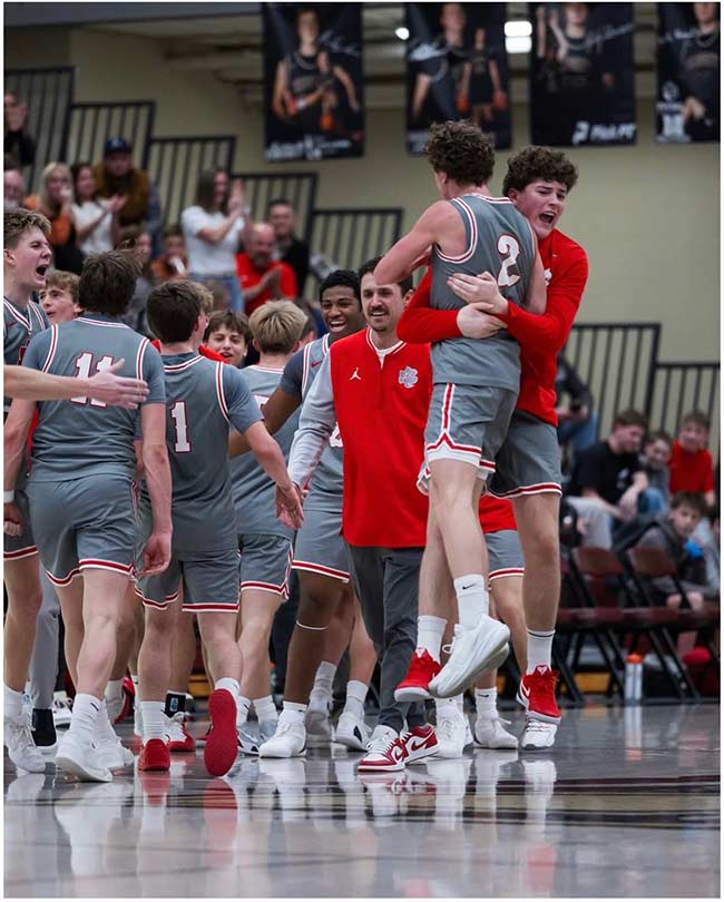 Logan Hamilton, center, walks on the court with his players after a recent victory. | Courtesy Logan Hamilton